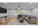 Comfortable living room with a sectional sofa, hardwood floors, and large windows at 5208 Melbourne Rd, Raleigh, NC 27606