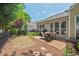 View of backyard patio with outdoor dining set, grill, and lush flower beds in a well-kept yard at 524 Clarenbridge Dr, Cary, NC 27519