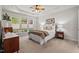 Spacious bedroom with a ceiling fan, tray ceiling, neutral walls and large windows overlooking the yard at 524 Clarenbridge Dr, Cary, NC 27519