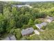 Aerial view of a neighborhood home surrounded by trees, with a lake visible in the distance at 5529 Shadowbrook Dr, Raleigh, NC 27612
