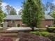 Brick home backyard with patio, steps, mature trees, and landscaping at 5529 Shadowbrook Dr, Raleigh, NC 27612