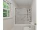 Bright bathroom featuring a shower-tub combination with glass door and tiled walls at 5529 Shadowbrook Dr, Raleigh, NC 27612