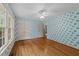 Bedroom featuring hardwood floors, ceiling fan, and wallpapered walls at 5529 Shadowbrook Dr, Raleigh, NC 27612