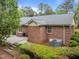 Rear exterior view of brick home featuring a patio and landscaped yard at 5529 Shadowbrook Dr, Raleigh, NC 27612