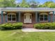 Inviting brick home featuring a covered front porch with decorative ironwork and well-maintained landscaping at 5529 Shadowbrook Dr, Raleigh, NC 27612