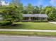 Charming brick home boasts lush landscaping, vibrant green lawn, and traditional architectural details at 5529 Shadowbrook Dr, Raleigh, NC 27612