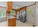 Traditional kitchen featuring wood cabinets, white appliances, and a stainless steel refrigerator at 5529 Shadowbrook Dr, Raleigh, NC 27612