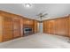 Spacious living room featuring wood paneled walls, fireplace and carpet flooring at 5529 Shadowbrook Dr, Raleigh, NC 27612
