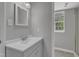 This bathroom features a nice vanity, mirror, window and tiled floors at 5602 Falls Of Neuse Rd # E, Raleigh, NC 27609
