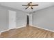 This is a bedroom featuring hardwood floors, a ceiling fan and multiple doors at 5602 Falls Of Neuse Rd # E, Raleigh, NC 27609