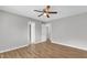 This is a bedroom featuring hardwood floors, a ceiling fan and multiple doors at 5602 Falls Of Neuse Rd # E, Raleigh, NC 27609