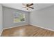 This is a bedroom featuring hard wood floors, a window and a ceiling fan at 5602 Falls Of Neuse Rd # E, Raleigh, NC 27609