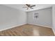 This is a bedroom featuring hard wood floors, a window and a ceiling fan at 5602 Falls Of Neuse Rd # E, Raleigh, NC 27609