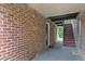Brick-walled hallway leading to an entry door and staircase at 5602 Falls Of Neuse Rd # E, Raleigh, NC 27609