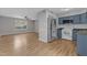 Open-concept kitchen and living room featuring stainless steel refrigerator and abundant natural light at 5602 Falls Of Neuse Rd # E, Raleigh, NC 27609