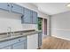 Well-lit kitchen with white appliances and shaker style cabinetry, leading to deck at 5602 Falls Of Neuse Rd # E, Raleigh, NC 27609
