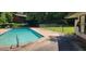 Relaxing community pool with a grassy area, green surroundings, and lounge chairs for a serene and enjoyable outdoor experience at 5602 Falls Of Neuse Rd # E, Raleigh, NC 27609