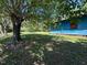 Backyard view of a blue house with a well-maintained lawn and mature tree at 5644B Old Roxboro Rd, Oxford, NC 27565