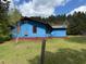 Exterior side view of a blue home with green lawn, and red trim at 5644B Old Roxboro Rd, Oxford, NC 27565