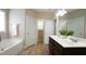 Bright and clean bathroom featuring tiled floors, a bathtub, and double sinks at 65 Wood Green Dr, Wendell, NC 27591