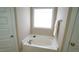 Bright bathroom featuring a bathtub under the window with tile surround at 65 Wood Green Dr, Wendell, NC 27591