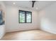 This light-filled bedroom features hardwood floors, neutral walls, and a dark window with backyard views at 661 Manchester Dr, Raleigh, NC 27609