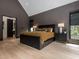 Modern bedroom features sleek dark accents, a vaulted ceiling, and light wood floors at 661 Manchester Dr, Raleigh, NC 27609