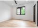 This bright bedroom features hardwood floors, neutral walls, and a dark trimmed window with backyard views at 661 Manchester Dr, Raleigh, NC 27609