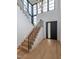Bright entryway features hardwood floors, modern staircase, and a sleek black front door with sidelight window at 661 Manchester Dr, Raleigh, NC 27609