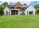Stunning exterior showcasing a modern home with a lush green lawn and professionally landscaped front yard at 661 Manchester Dr, Raleigh, NC 27609