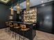 Stylish home bar with liquor display, black cabinetry, and pendant lighting at 661 Manchester Dr, Raleigh, NC 27609