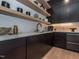 Contemporary kitchen with light wood shelving, dark cabinets, and quartz countertops at 661 Manchester Dr, Raleigh, NC 27609