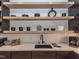 Kitchen area features open shelving with decorative dishware, quartz countertop, and dark cabinets at 661 Manchester Dr, Raleigh, NC 27609