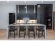 Elegant kitchen island boasts dark cabinets, pendant lighting and bar seating for four at 661 Manchester Dr, Raleigh, NC 27609