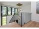 Modern staircase with black metal railing and striking chandelier with neighborhood view from windows at 661 Manchester Dr, Raleigh, NC 27609