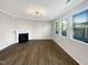 Bright living room featuring a fireplace, hardwood floors and large windows at 664 Lavenham Ln, Fuquay Varina, NC 27526