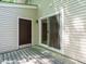 Exterior view of a weathered wooden back deck with a sliding glass door and a dark-colored access door at 7408 Sandy Creek Dr, Raleigh, NC 27615