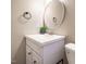 Updated bathroom with white vanity, round mirror and modern fixtures at 7408 Sandy Creek Dr, Raleigh, NC 27615