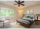 Cozy bedroom with ceiling fan, window view, queen bed, and lamps at 7408 Sandy Creek Dr, Raleigh, NC 27615