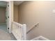 Hallway view of staircase with white railings and access to rooms at 7408 Sandy Creek Dr, Raleigh, NC 27615
