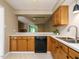 Bright kitchen with stainless steel sink, black dishwasher, and view of the open concept living space at 7408 Sandy Creek Dr, Raleigh, NC 27615