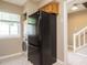 Galley kitchen featuring a black fridge, stackable washer/dryer and view of the open stairs at 7408 Sandy Creek Dr, Raleigh, NC 27615