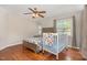 Comfortable bedroom featuring a ceiling fan, hardwood floors and a crib next to a window at 776 Averasboro Dr, Clayton, NC 27520