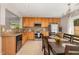 Well-lit kitchen and dining area with wood cabinets, stainless steel appliances, and a modern chandelier at 776 Averasboro Dr, Clayton, NC 27520