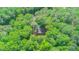 Aerial view showing a cozy house surrounded by lush green trees at 9614 Quail Roost Rd, Bahama, NC 27503