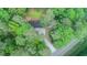 Aerial view of a home nestled among trees with a long driveway at 9614 Quail Roost Rd, Bahama, NC 27503