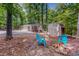 Backyard featuring a shed, fire pit with chairs, and a scenic wooded area, perfect for outdoor enjoyment at 9614 Quail Roost Rd, Bahama, NC 27503