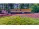 Rear of house with brown exterior, partial brick foundation, storage shed, and grassy yard at 9614 Quail Roost Rd, Bahama, NC 27503