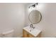 Bathroom with vanity, toilet, new lighting, round mirror, and tile shower at 9614 Quail Roost Rd, Bahama, NC 27503