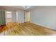 Open bedroom with hardwood floors, featuring an adjacent closet and hallway to the bathroom at 9614 Quail Roost Rd, Bahama, NC 27503